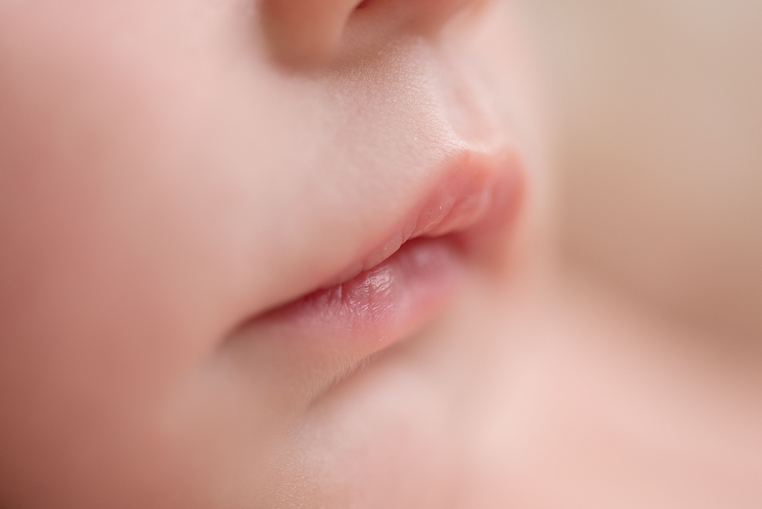 Close-up macro photo of pink lips and skin with soft focus and shallow depth of field.