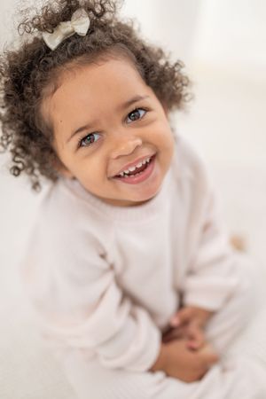 A series of four photos showing joyful expressions and curly hair against a white background.