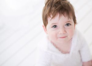A series of four similar photos showing a young child with rosy cheeks against a white background.