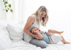 A group of people relaxing together on white bedding while wearing casual loungewear.