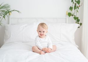 A series of four connected photos showing a bright white nursery with green plants and bedding.