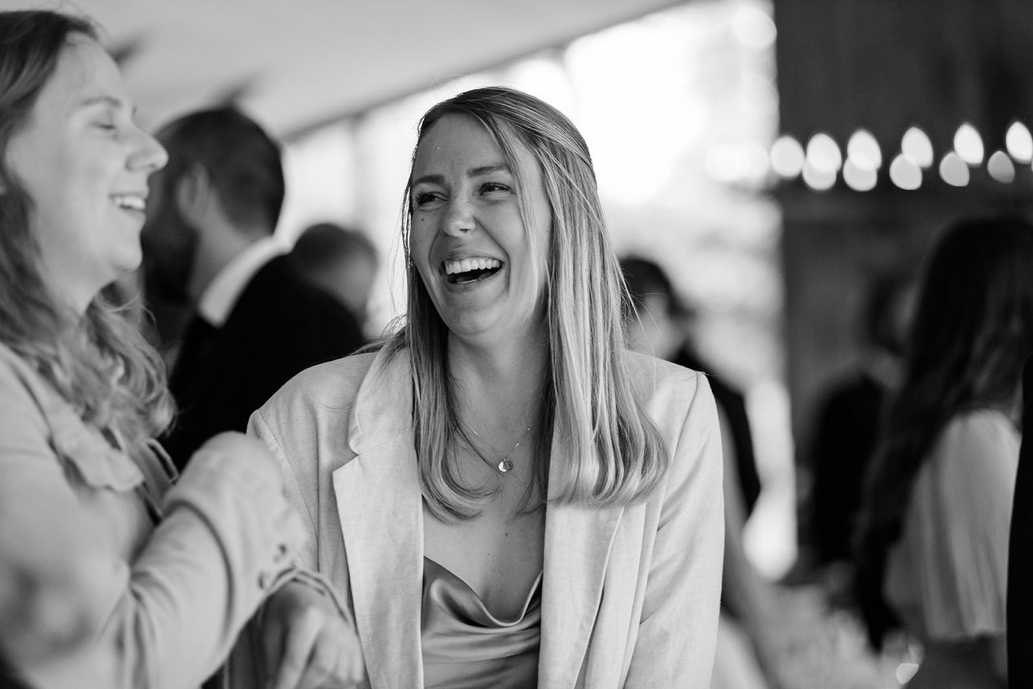 Black and white candid photos showing people laughing and enjoying a social gathering in a casual setting.