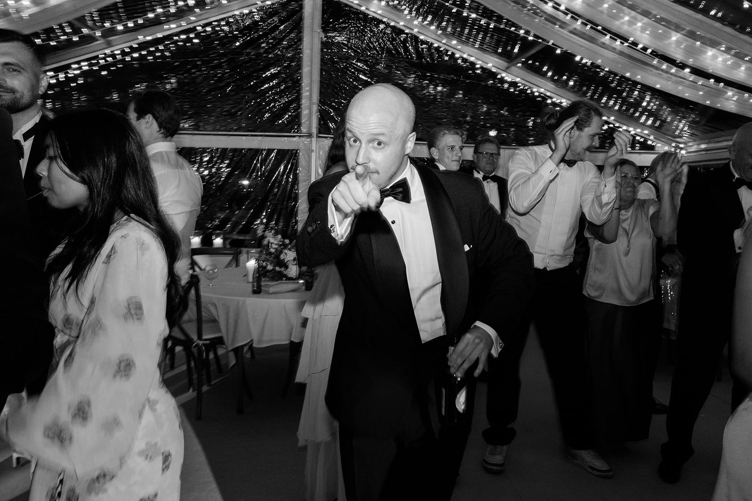 Wedding guests dance together on the dance floor during an energetic reception celebration.