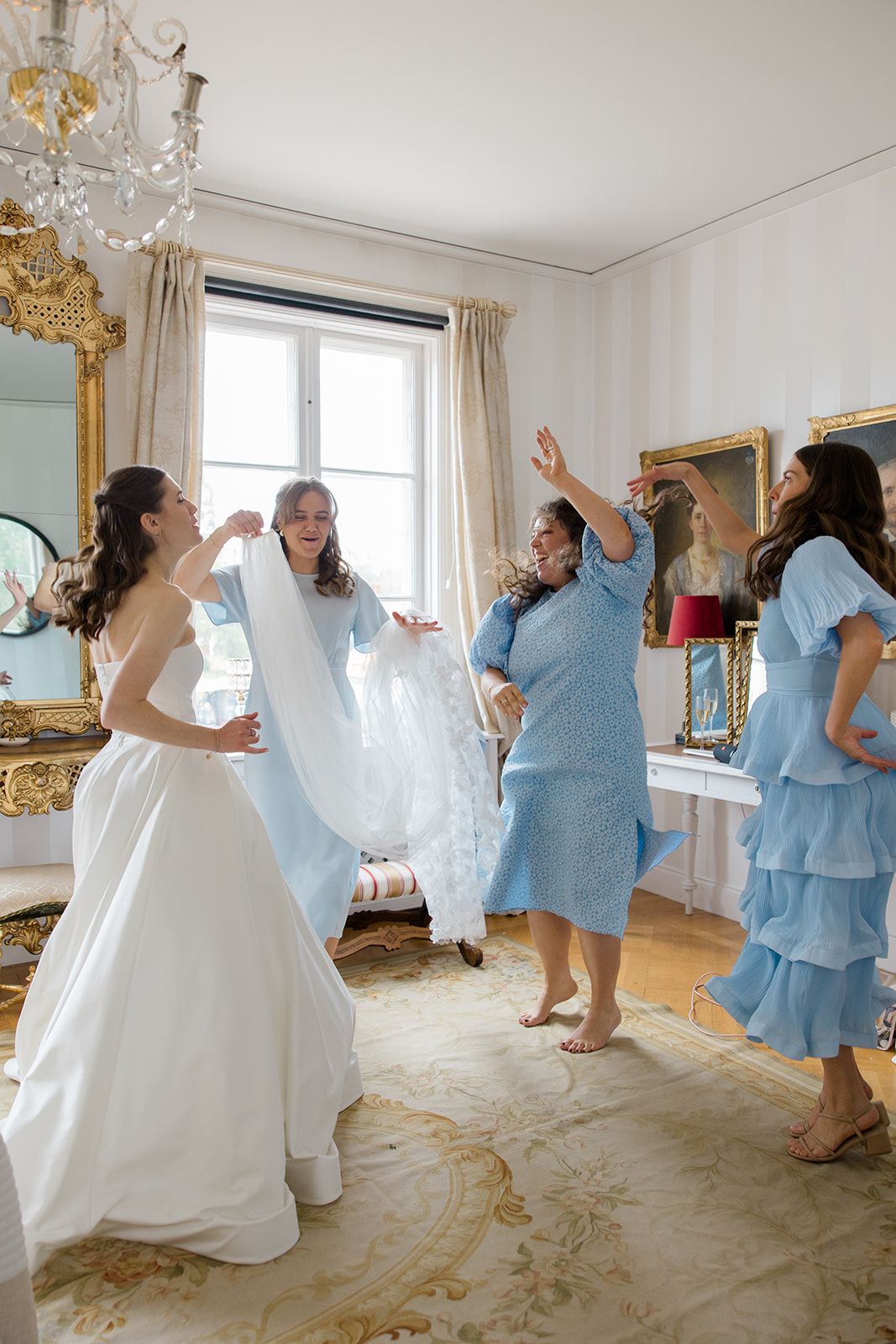 A series of joyful dance photos showing people in light blue bridesmaid dresses and white wedding gowns celebrating together.