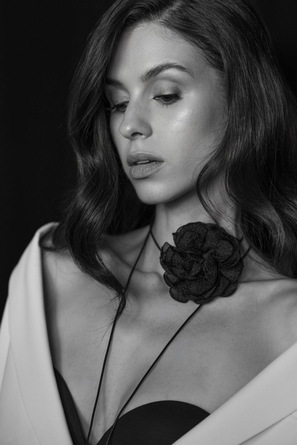 Black and white artistic portrait series showing a woman with a dark rose against dramatic shadows and contrasts.
