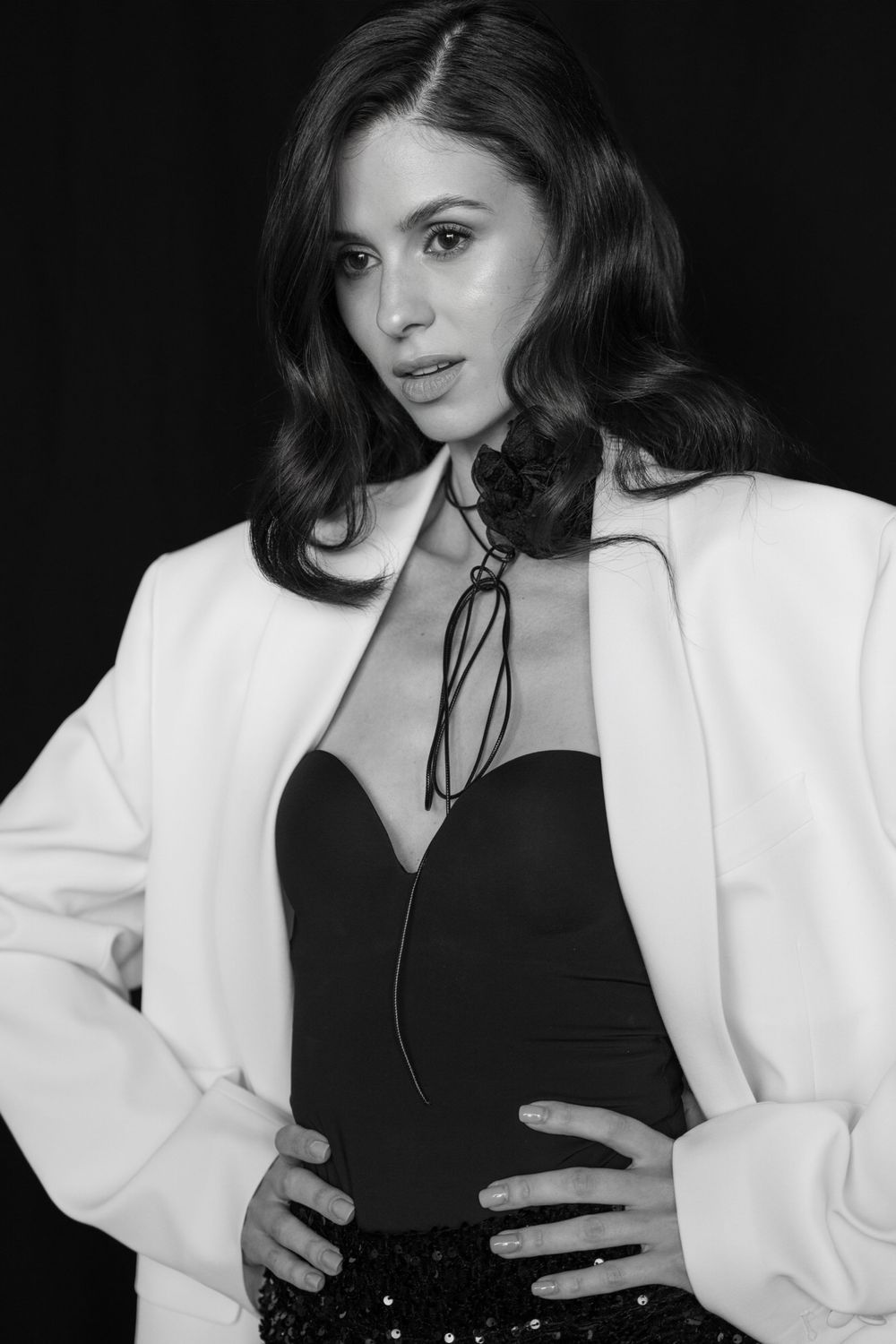 A black and white fashion portrait series showing a model in a white blazer and black top striking different poses.