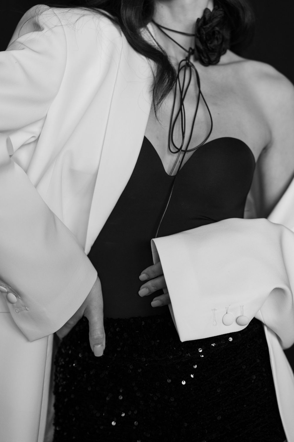 Fashion detail shots showing contrast between black dress and white ruffled statement sleeves.
