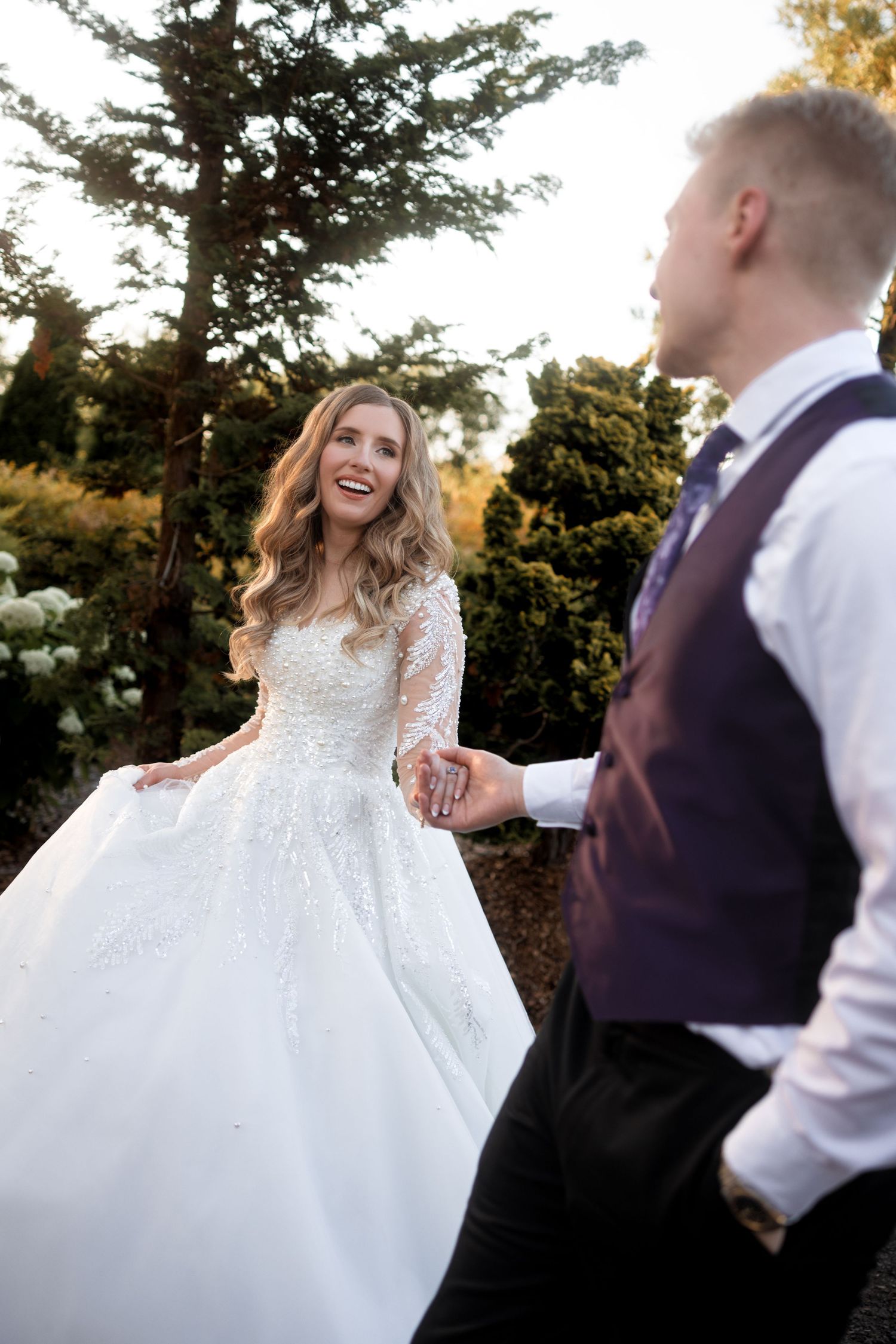 Couple shares romantic moments during sunset wedding photos outdoors.