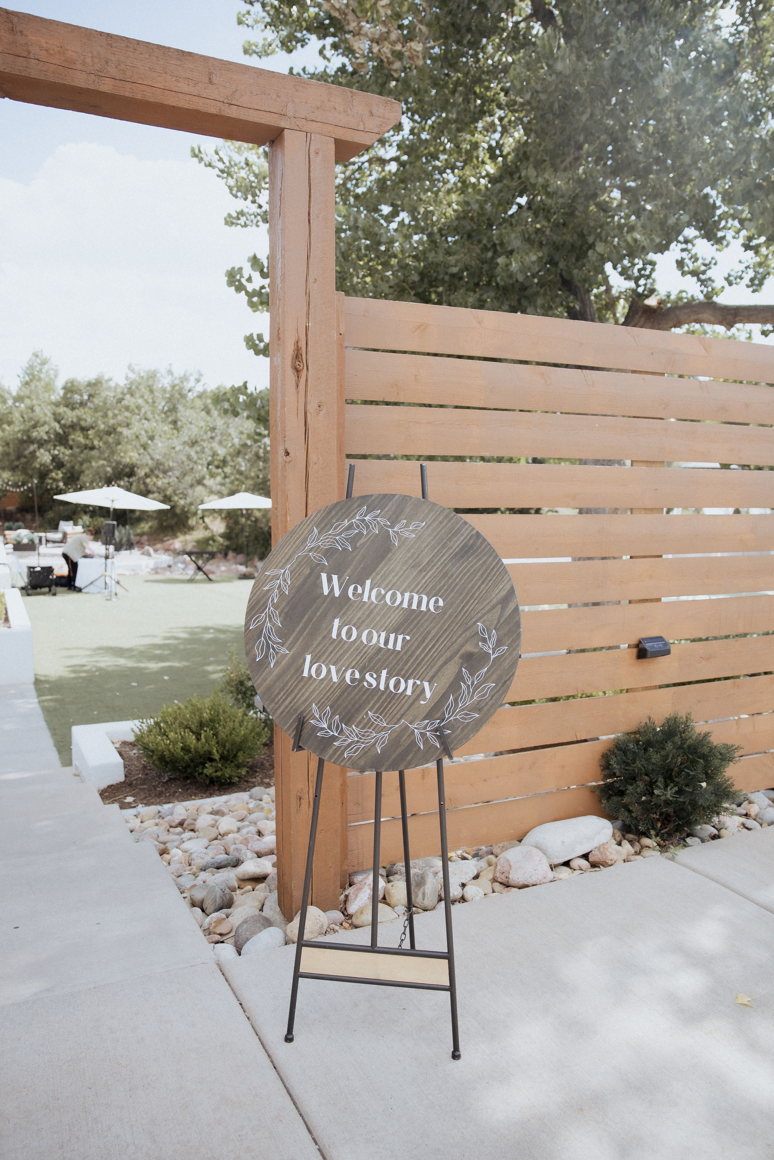 Three decorative slate signs with romantic text displayed on wooden stands against a white snowy backdrop and wooden fence.