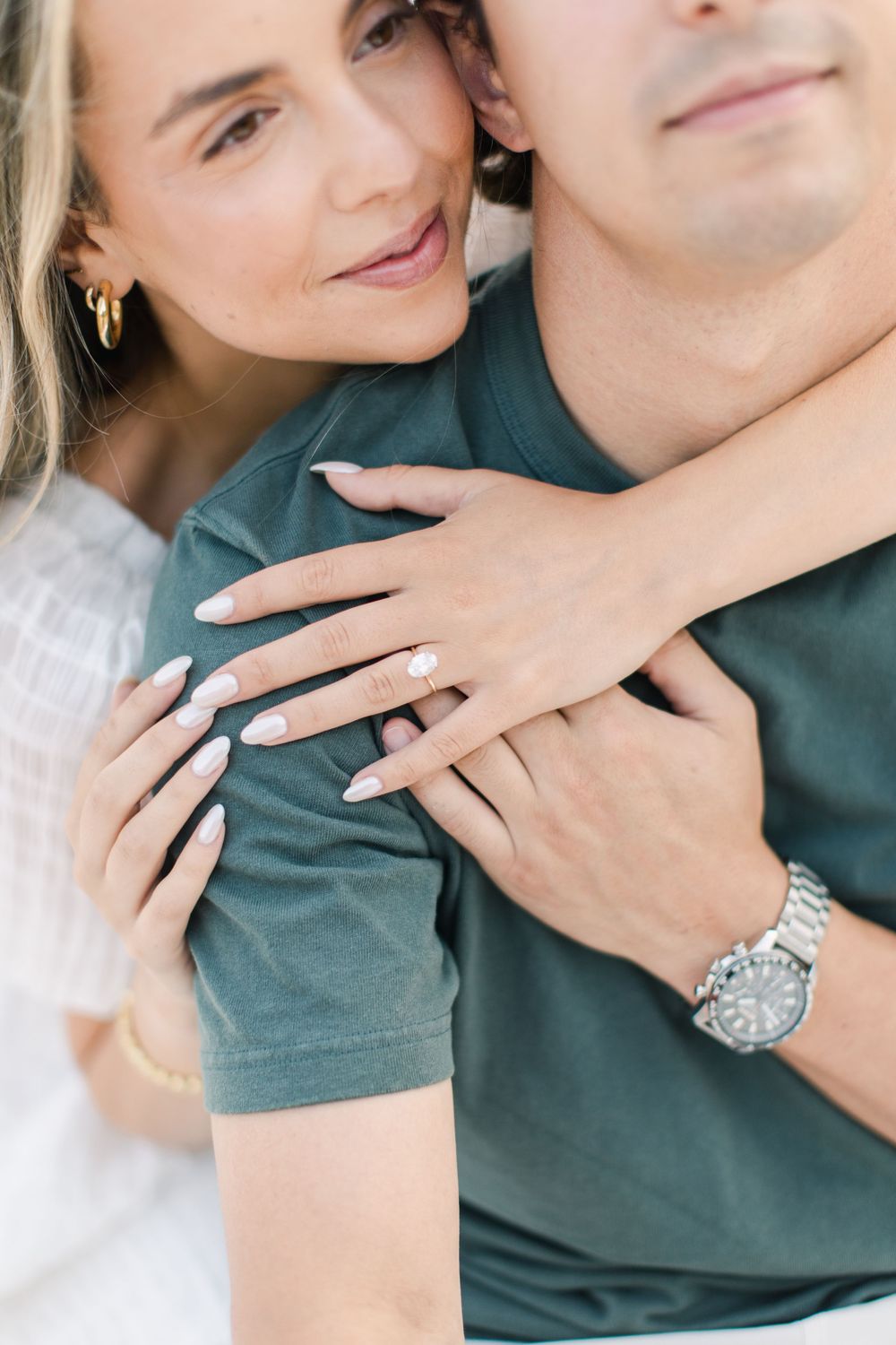 Close-up shots showing hands with engagement ring against a green shirt.