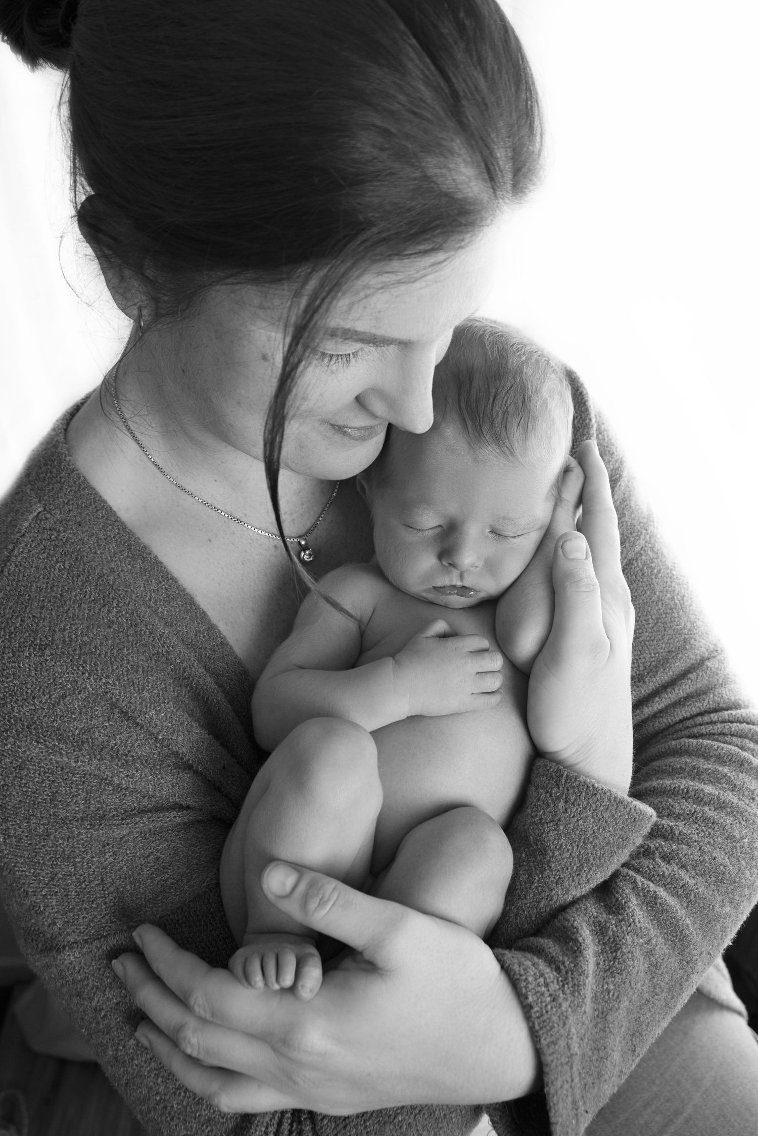 Professional newborn portrait in Gilston home studio with soft cream textures.