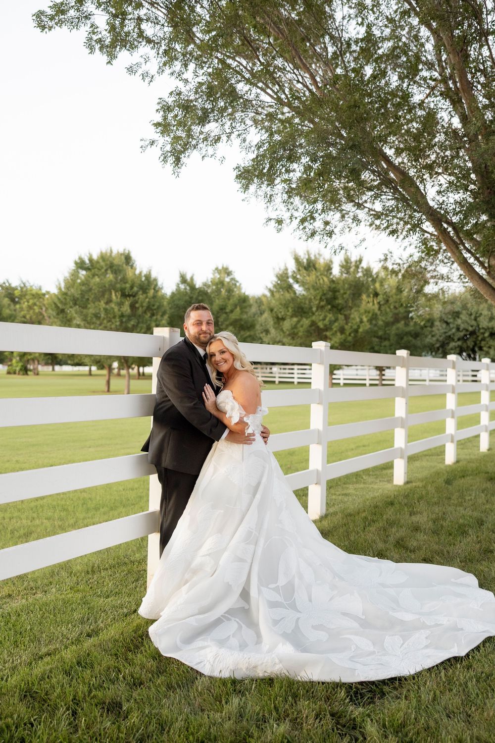White picket fence and lush green lawn frame an elegant outdoor scene with flowing white fabric.