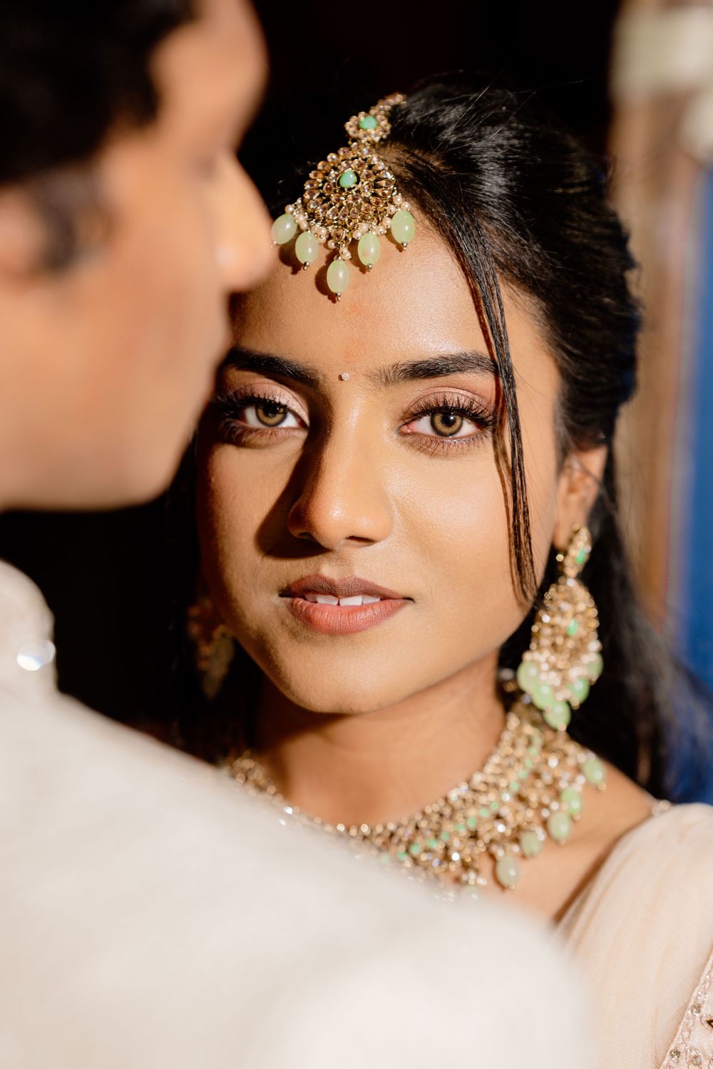 Close-up portrait shots featuring traditional Indian bridal jewelry and makeup with soft lighting.