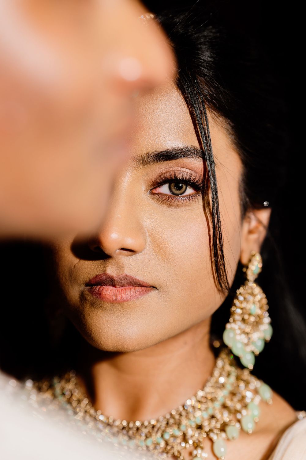 Close-up beauty shots showing ornate pearl jewelry and traditional Indian bridal accessories against a dark background.