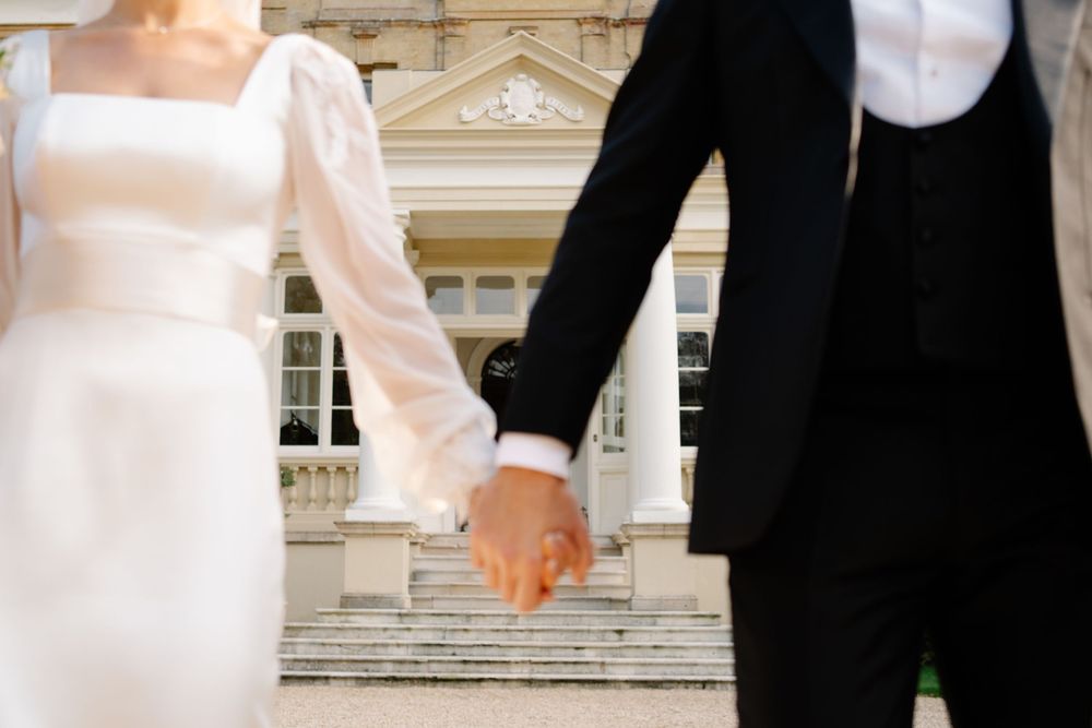 Bride and groom laughing together holding hands during golden hour couple portraits at a Hampshire wedding Pylewell park
