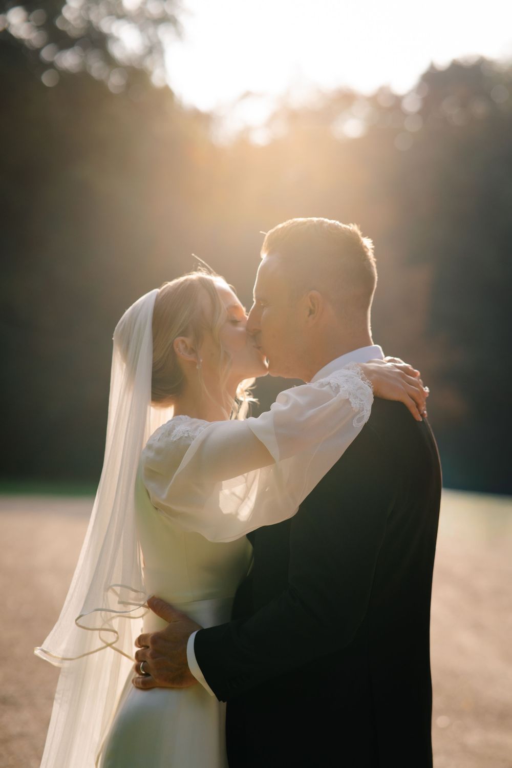 Bride and groom kissing with passion during golden hour couple portraits at a Hampshire wedding Pylewell park