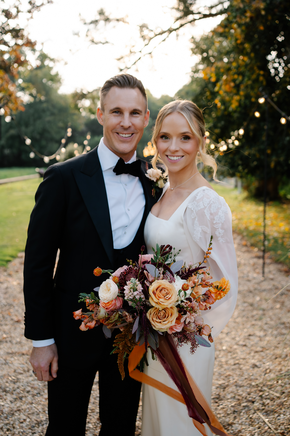 Bride and groom holding each other in October time wedding with florals at Hampshire wedding at Pylewell park