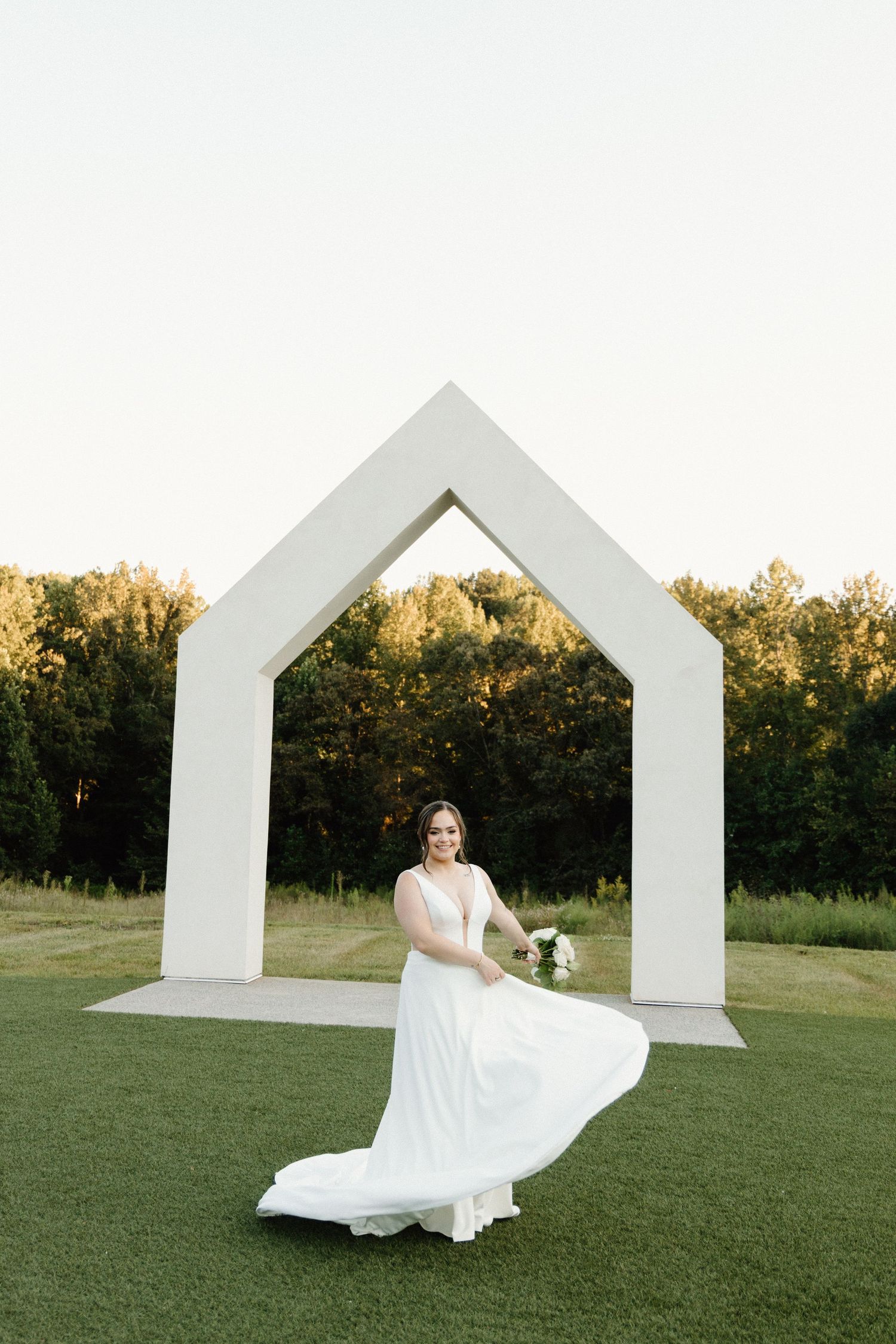 A sequence of photos shows a bride in a flowing white dress twirling in front of a modern white geometric arch structure.