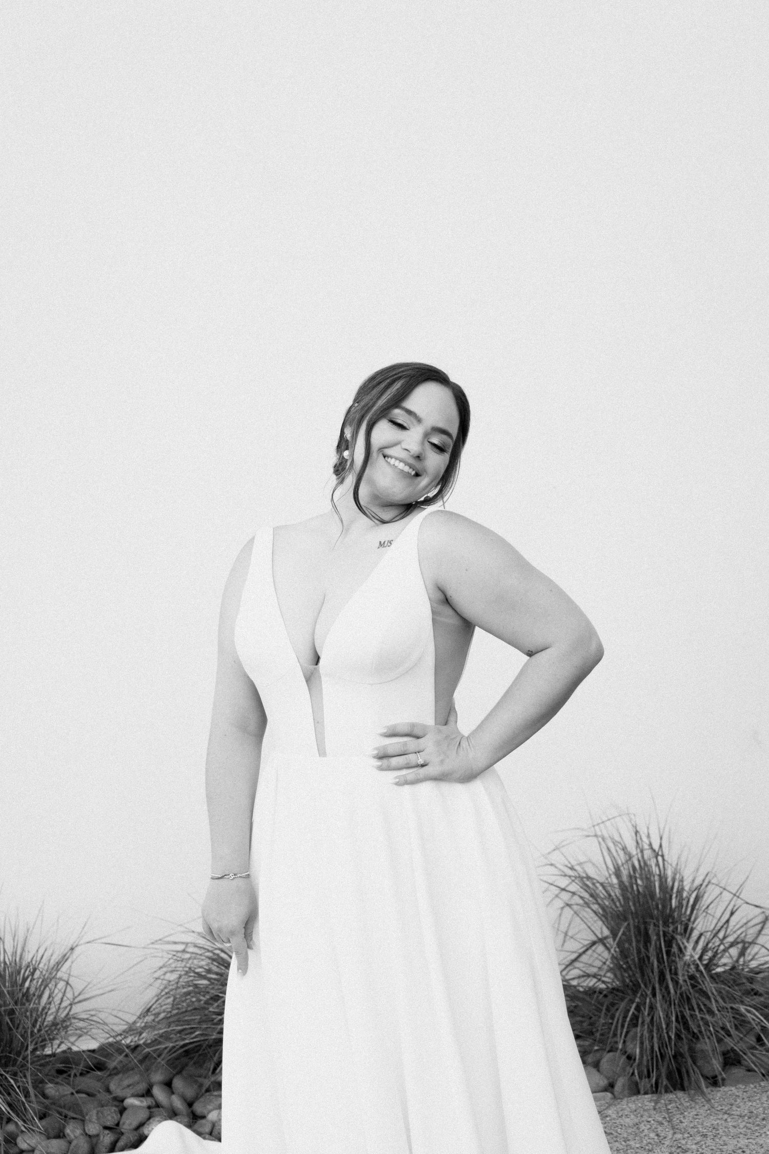A black and white photo series shows someone posing outdoors in a flowing white dress against natural foliage.