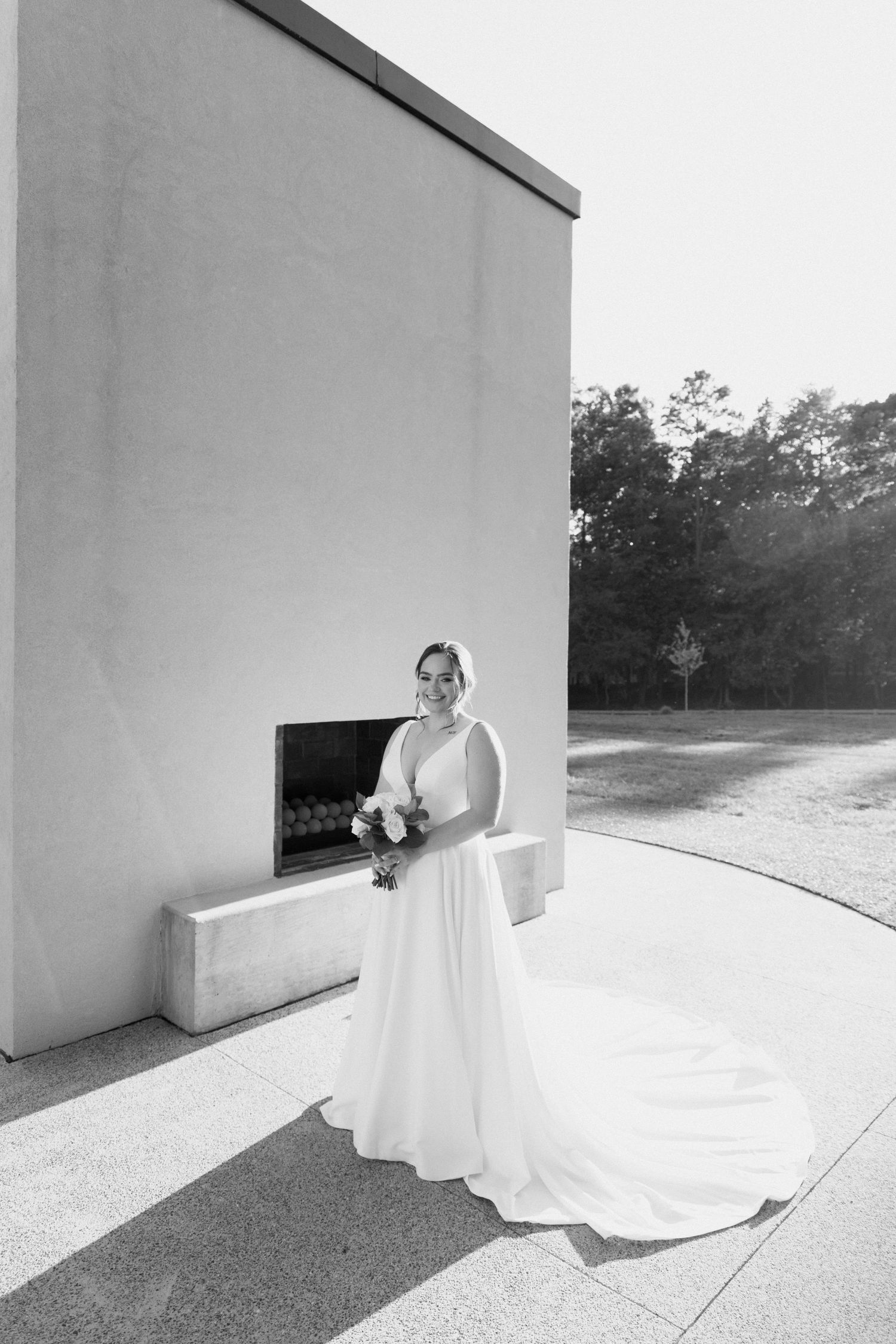 Artistic black and white series showing a flowing white wedding dress against minimalist architectural backdrop.