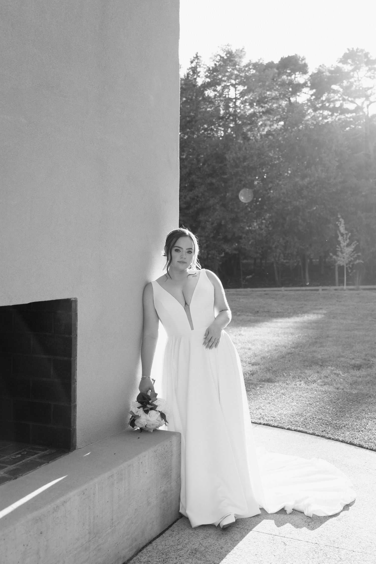 A series of black and white photographs showing a person in a white dress standing in various poses against a wall outdoors.
