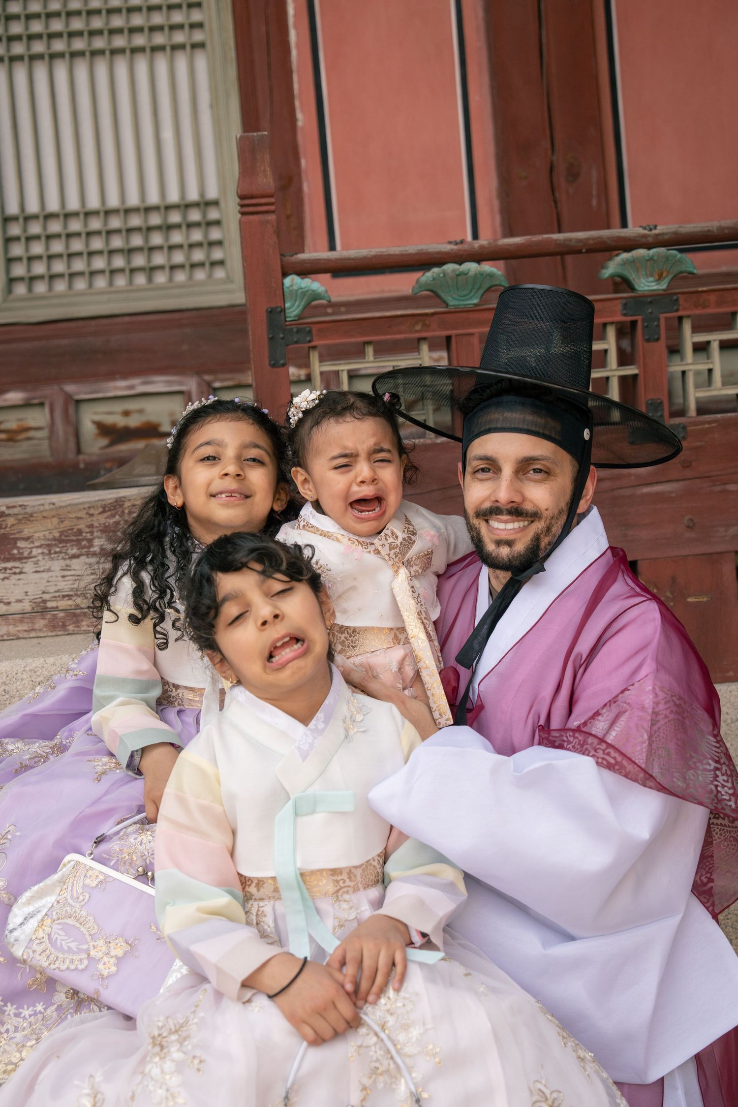 A family wearing traditional Korean hanbok clothing poses playfully together in a series of candid shots.