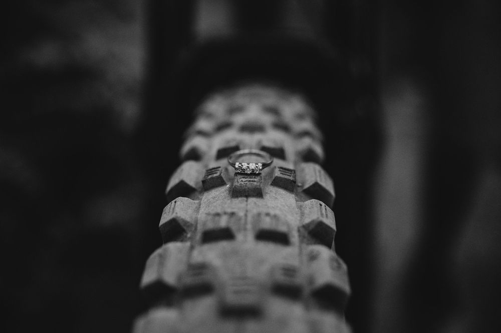 Adventurous couple engagement session photo of bike tire with engagement ring on tire in Cumberland Forest Vancouver Island