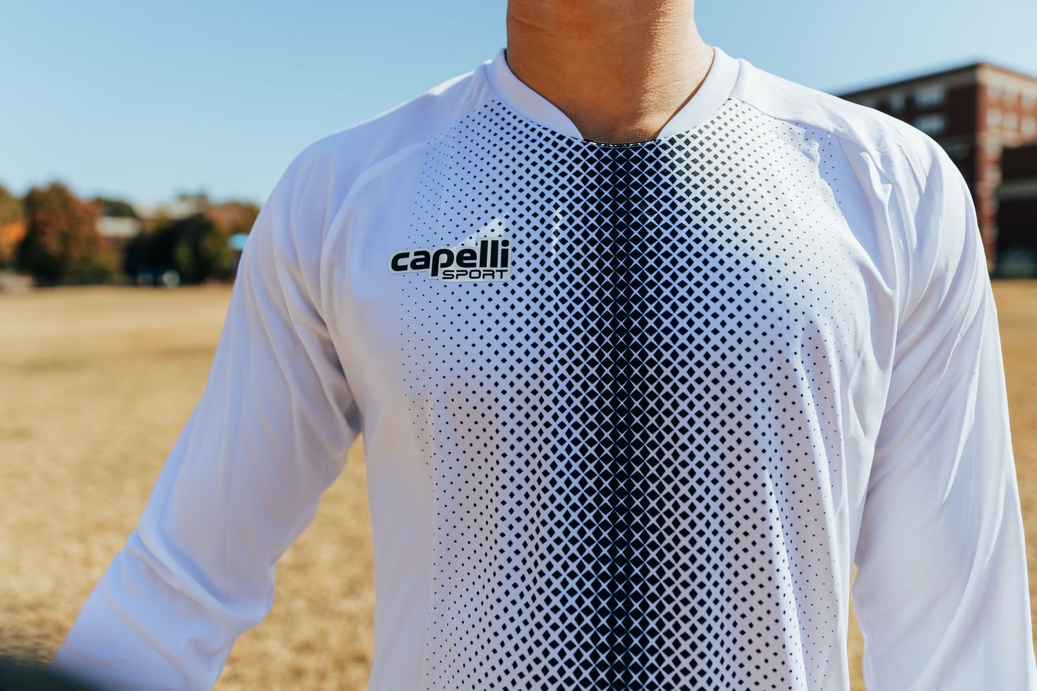 White Capelli Sport long-sleeve jersey with gradient dot pattern design on a male model outdoors.