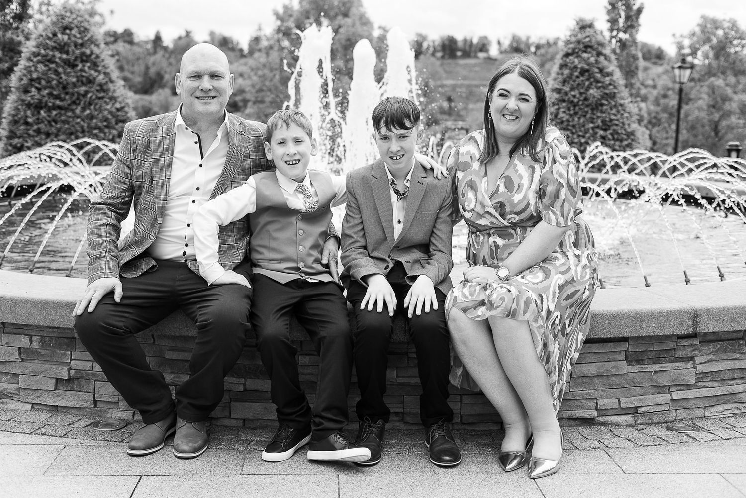 A black and white collage of people sitting together on outdoor steps and walls showing casual family moments.