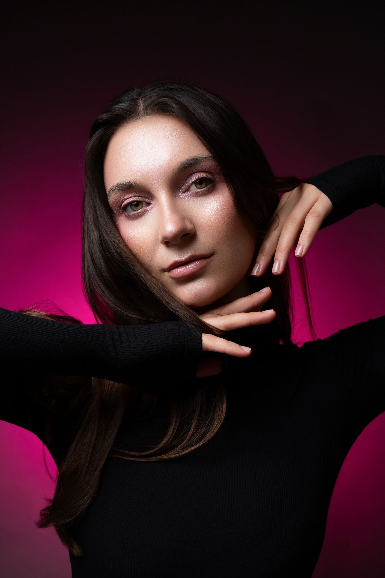 Artistic portrait against dark background with pink gradient lighting creating dramatic shadows and mood.