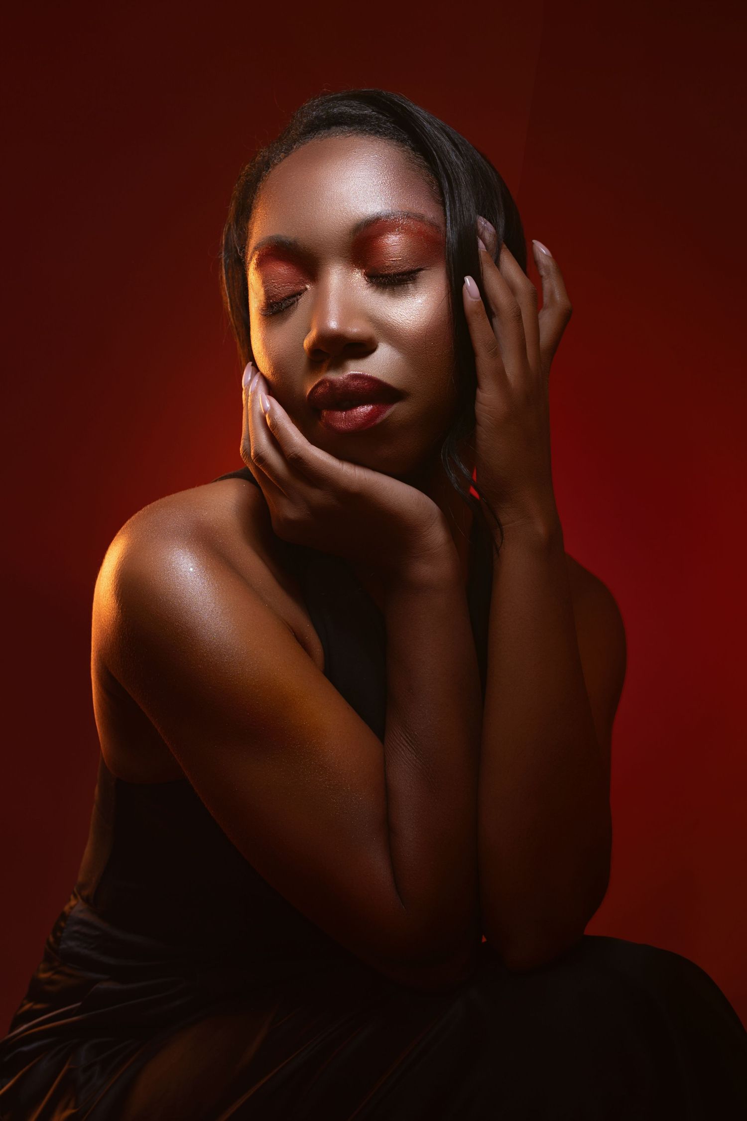 Artistic portrait series in dark red lighting showing dramatic poses and shadows against deep burgundy background.