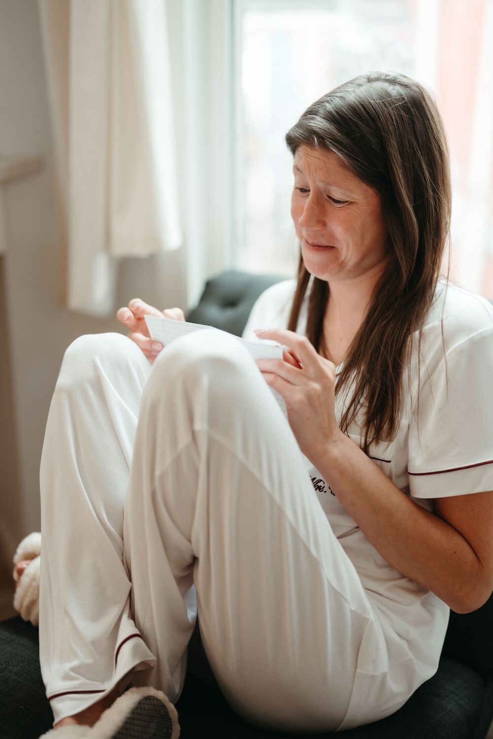 Person in white clothing lying on dark couch showing various relaxed poses in bright interior setting.