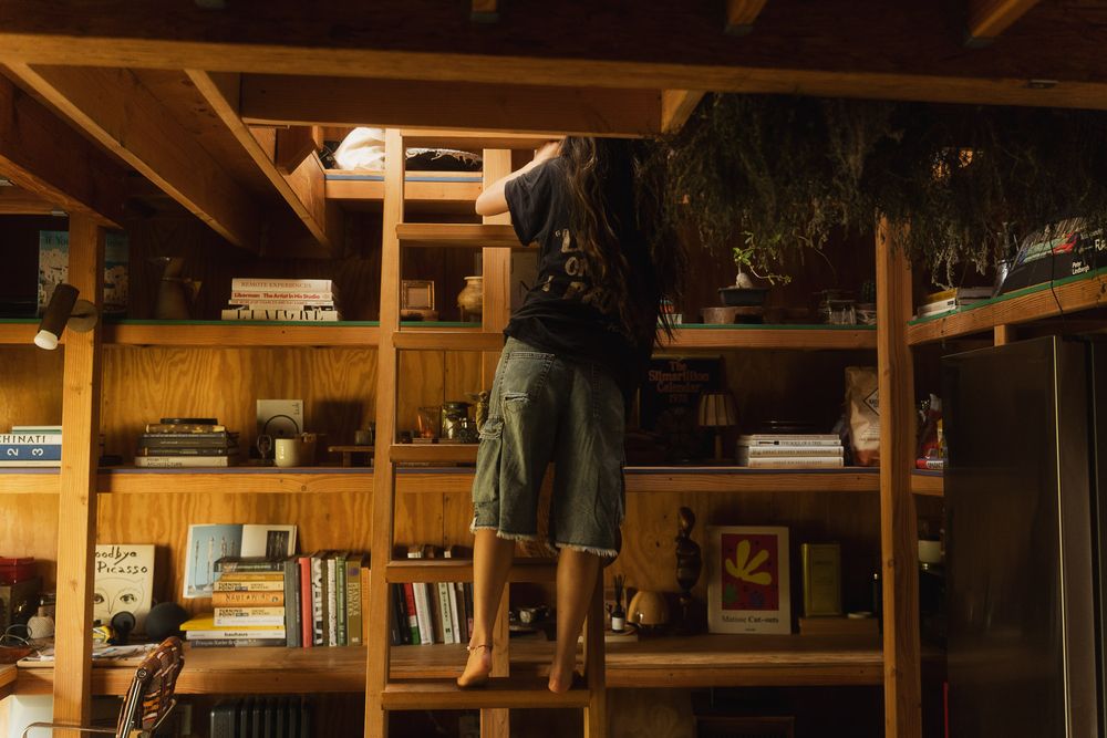 Female entrepreneur standing in her home library during a lifestyle shoot.