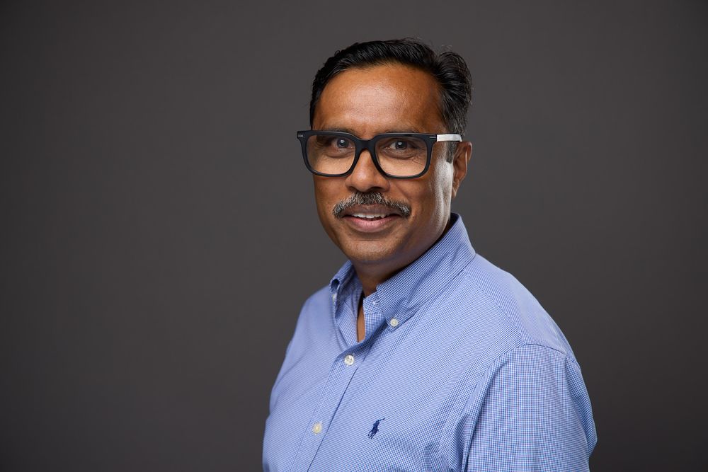 Professional headshot series showing a person in glasses and blue button-down shirt smiling against dark background.