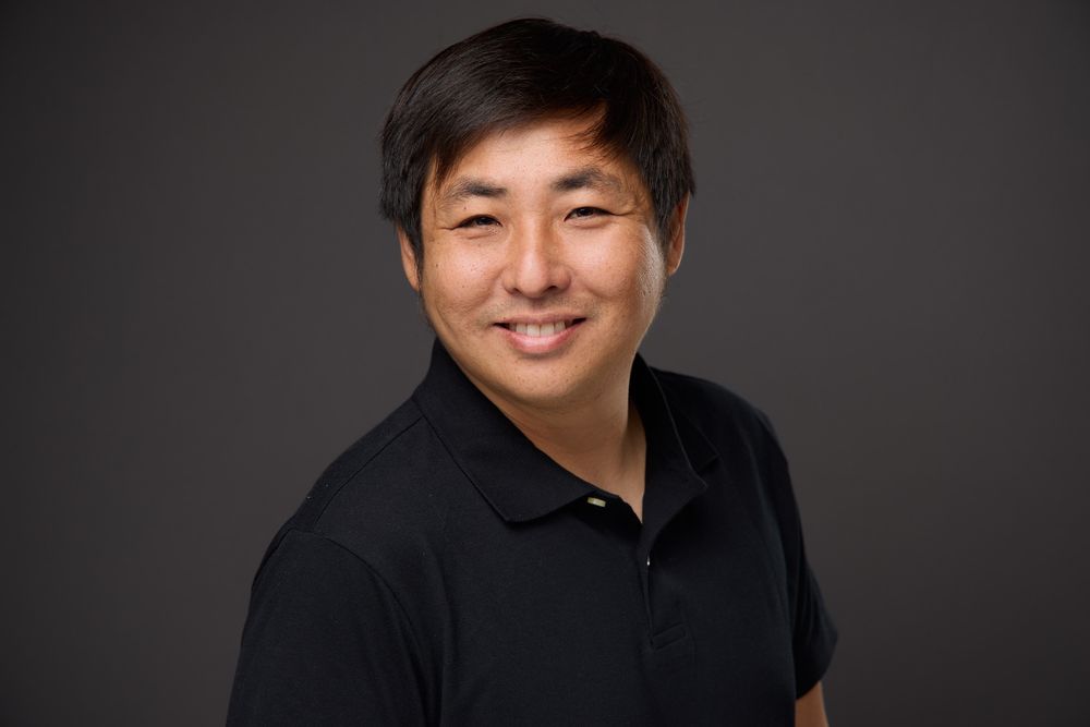 Professional headshot portraits against dark gray background showing someone in black attire smiling warmly.