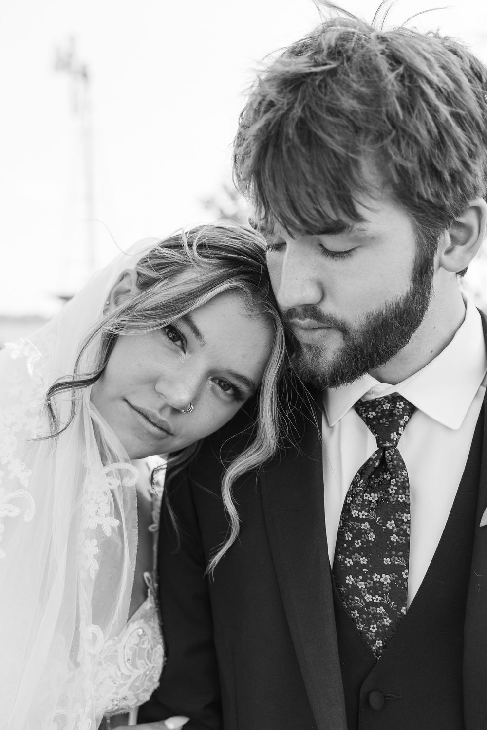 A romantic couple in formal attire shares intimate moments in a series of black and white photographs.