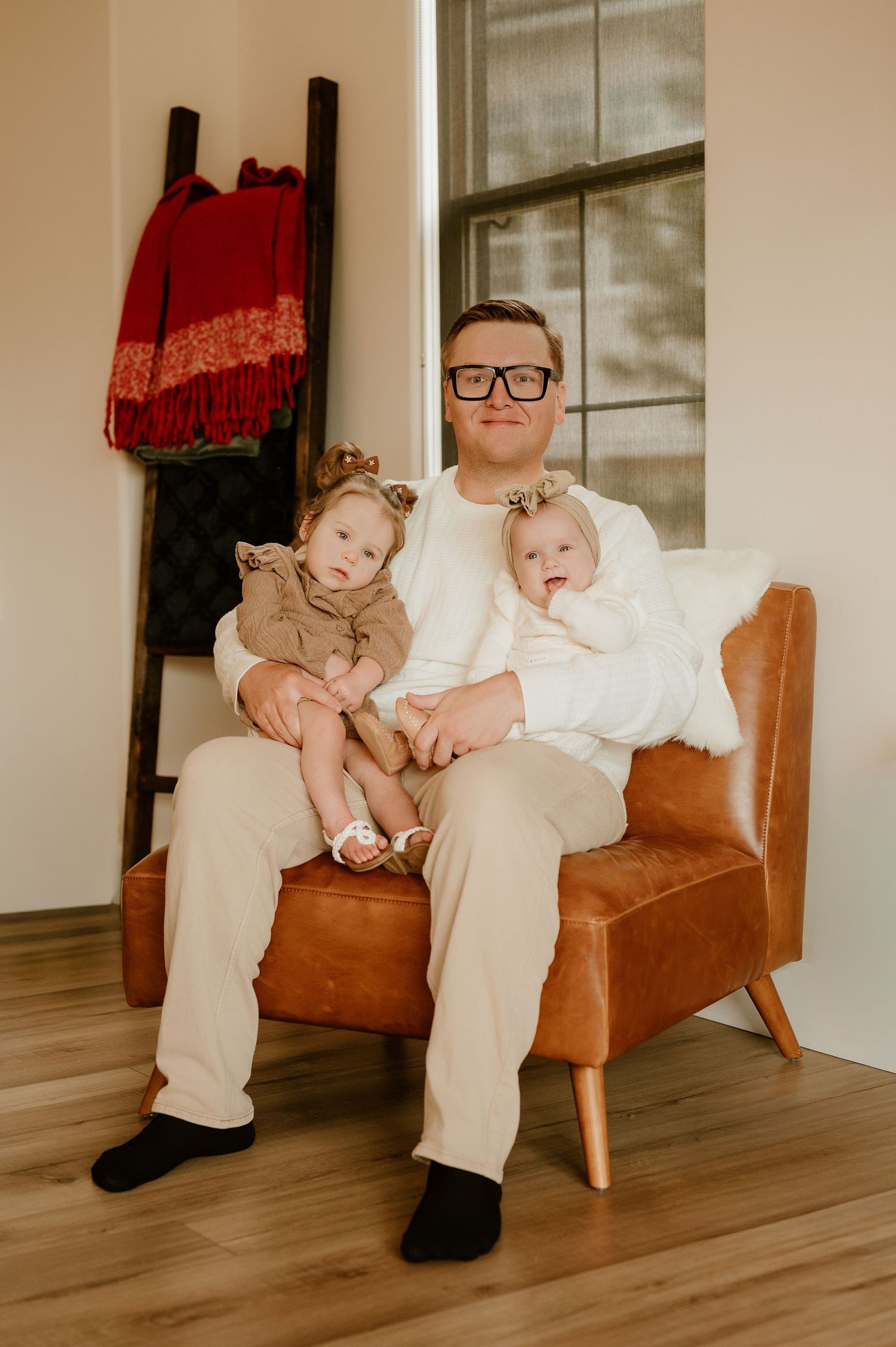 Series of warm-toned photos showing tender moments on a brown leather chair in a minimalist room.