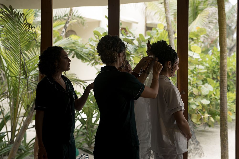 A group of people standing together in an outdoor walkway surrounded by lush tropical palm plants.