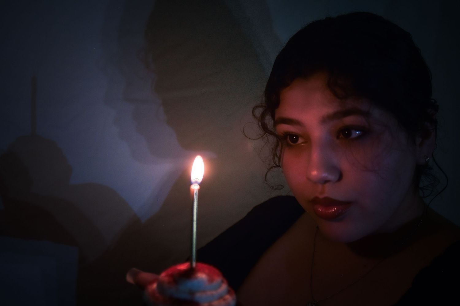 A sequence of dark moody photos showing someone lighting and blowing out candles in dramatic lighting.