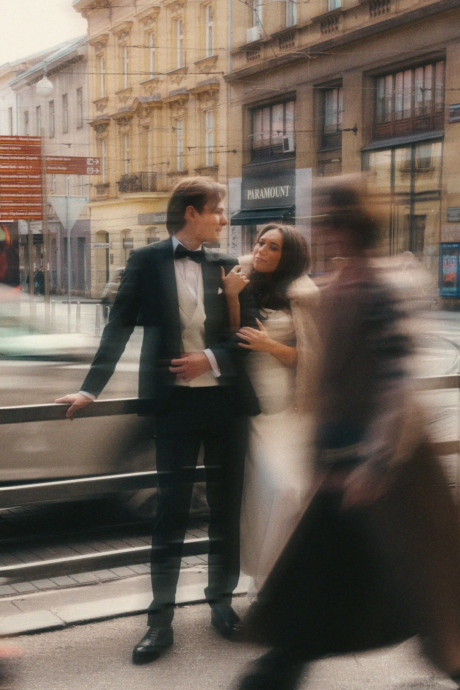 Motion blur captures business people passing on a city street with historic architecture in the background.