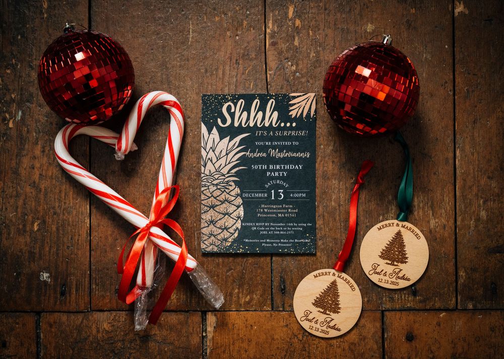 Red Christmas ornaments and candy canes arranged with wooden decorations on dark wooden background.
