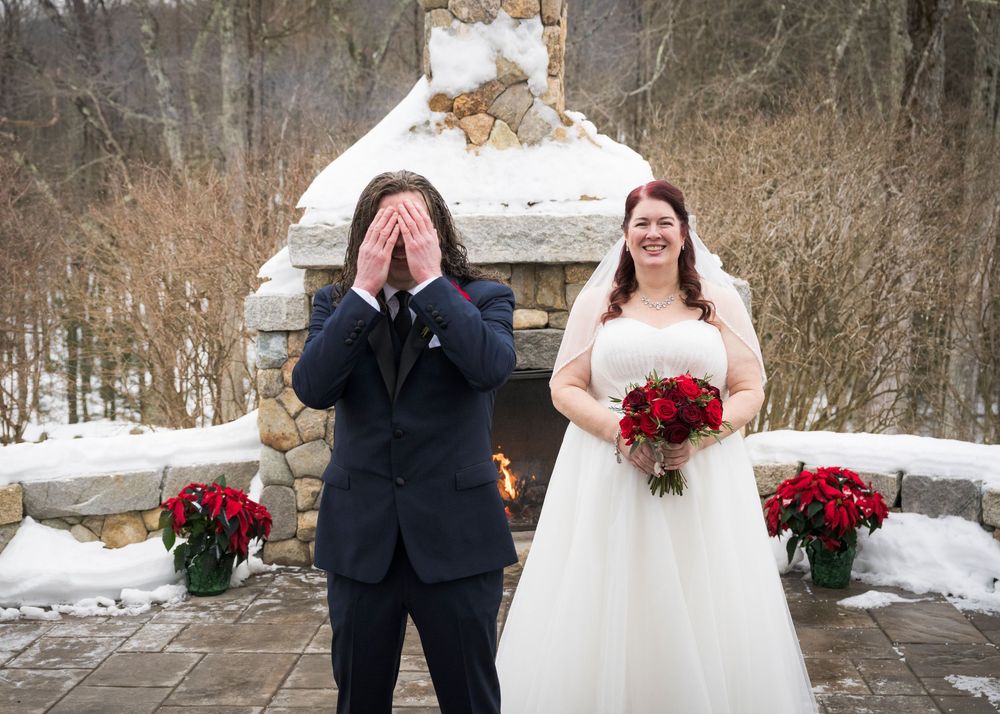 Winter wedding scene with snowy landscape and red floral bouquet.