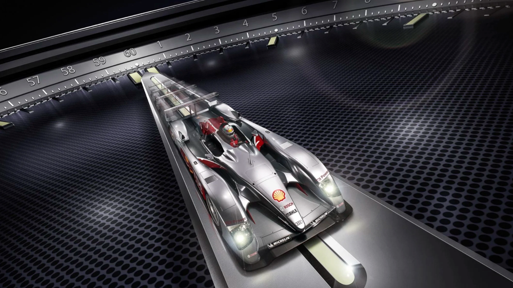 Sleek silver Formula 1 racing car on futuristic metallic grid surface with dramatic lighting.