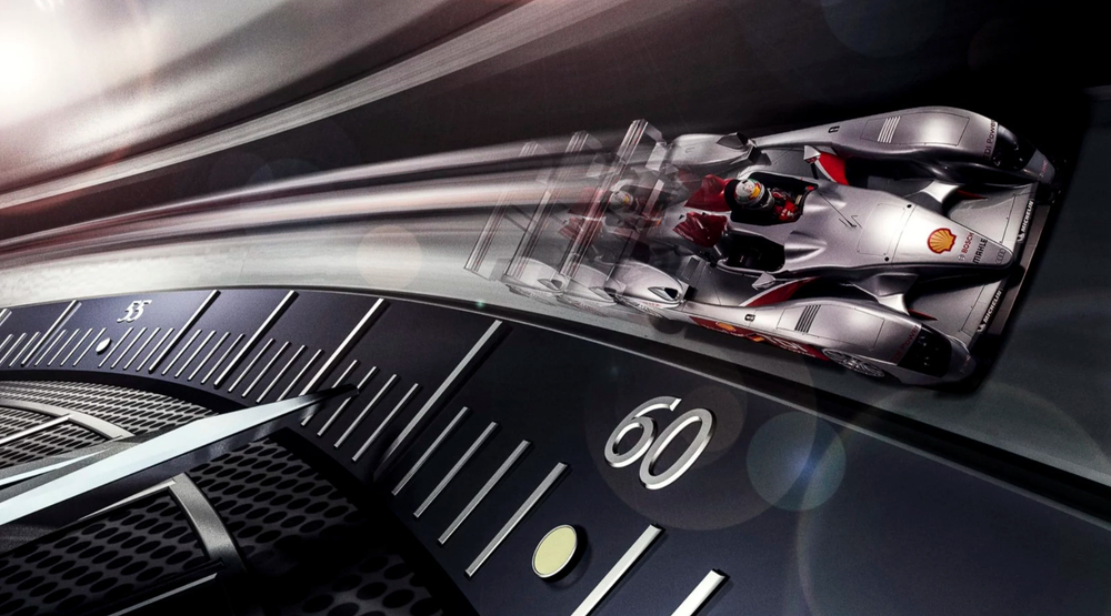 Luxury watch dial detail with dramatic motion blur effect showing racing car reflection on glass surface.