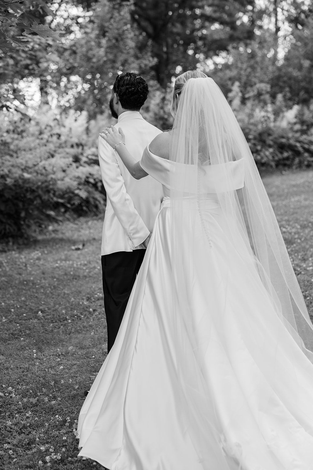 Black and white photo series showing a couple's joyful first look moment at an outdoor wedding ceremony.