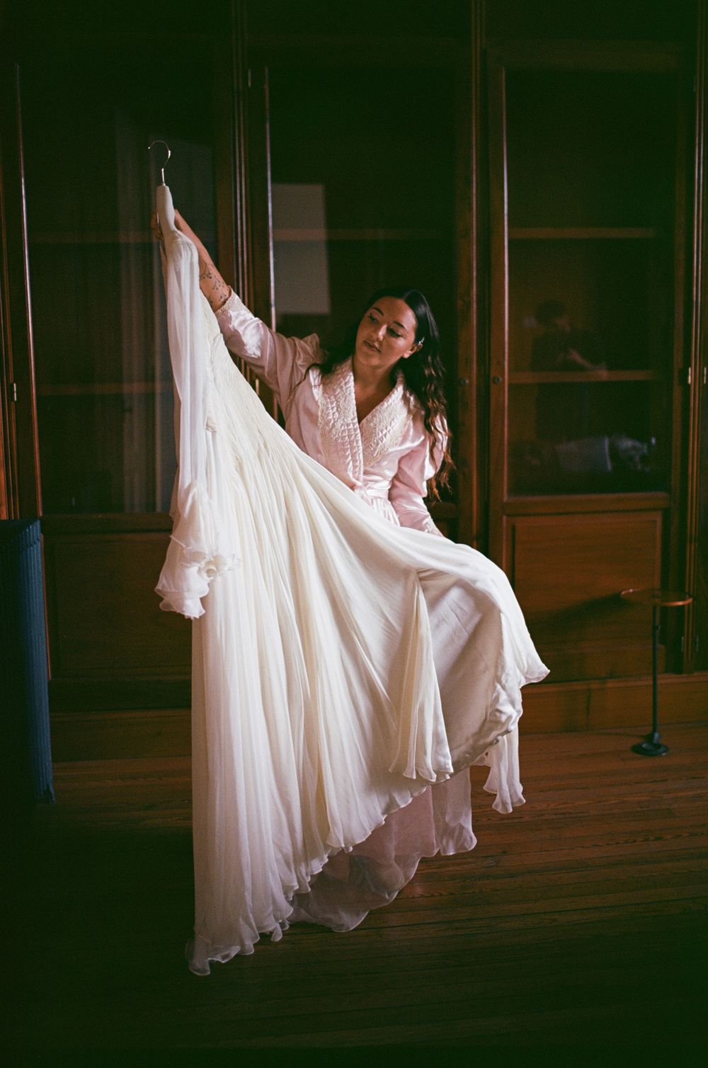 A series of four artistic photos showing dancers in flowing white dresses performing graceful movements in a dark space.