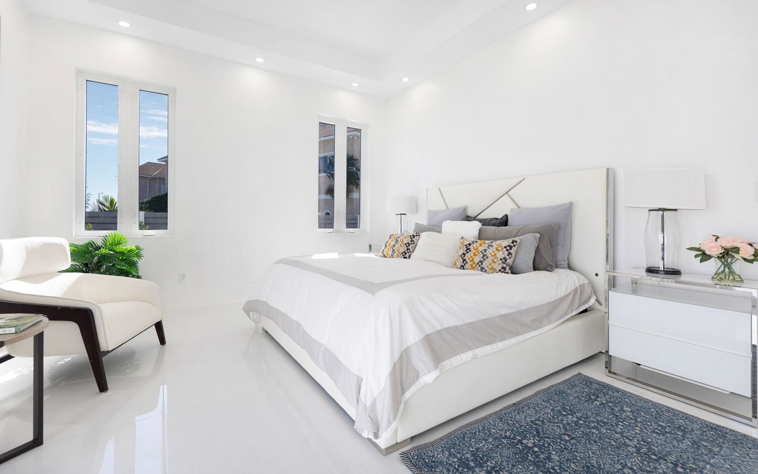 Modern white bedroom interior design with gray carpet and minimalist decor showcases clean lines and natural light.
