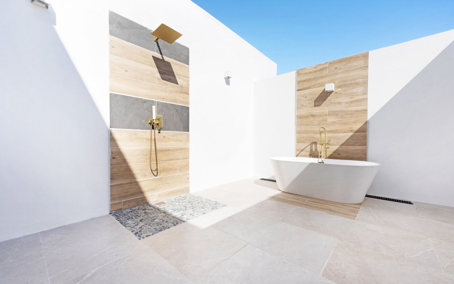Modern minimalist white room interior with geometric shapes and natural light streaming through skylights.