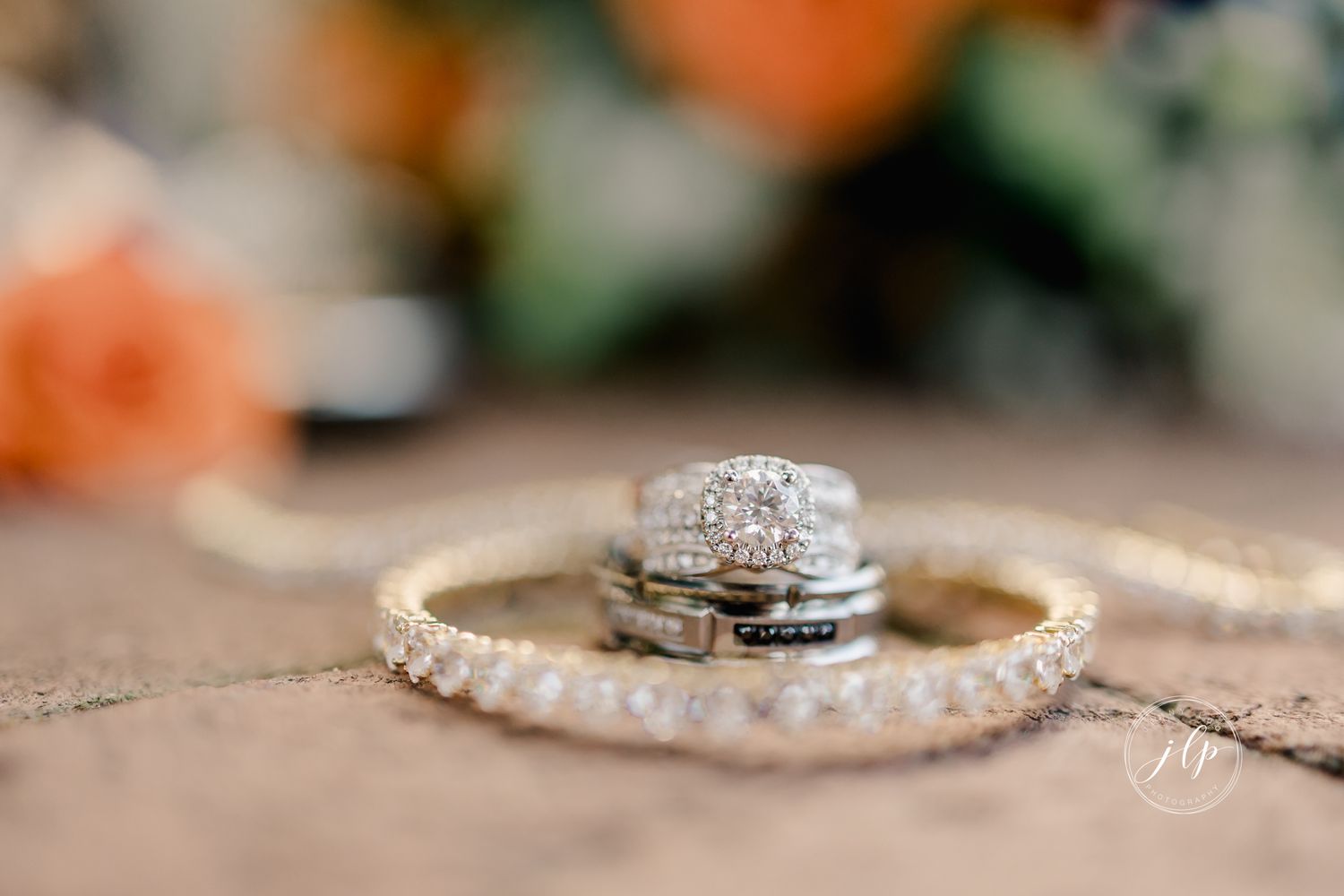 Close-up of sparkling diamond wedding rings and bands arranged on a textured surface.