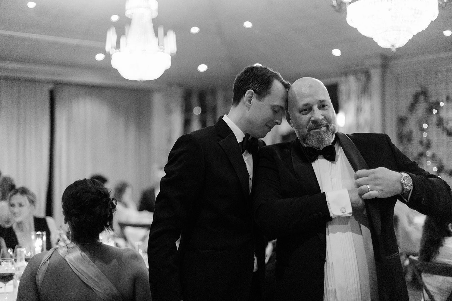 Black and white photos of couples dancing and embracing at an elegant wedding reception with crystal chandeliers.